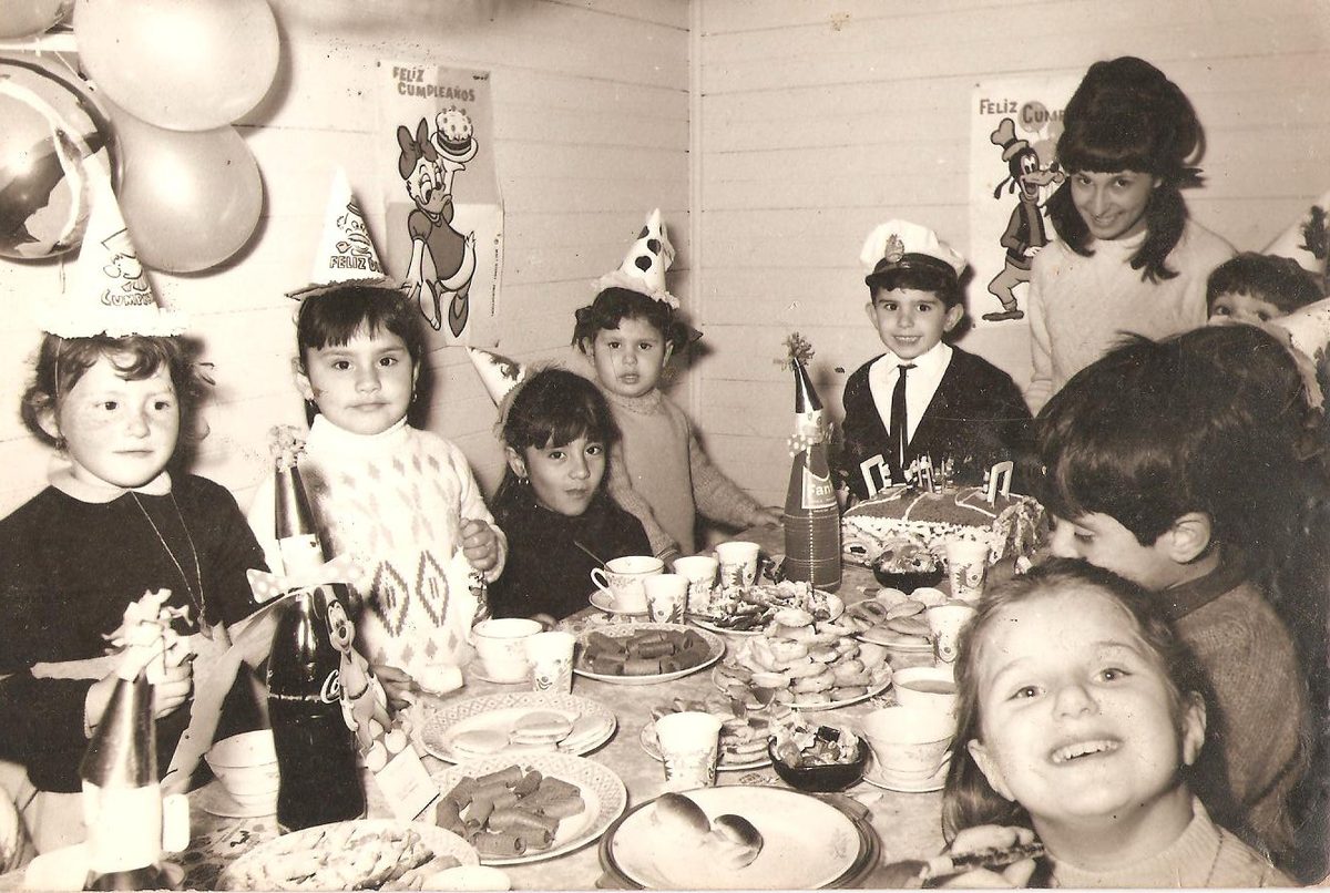 Foto original de un cumpleaños infantil, en blanco y negro, con manchas y desgaste